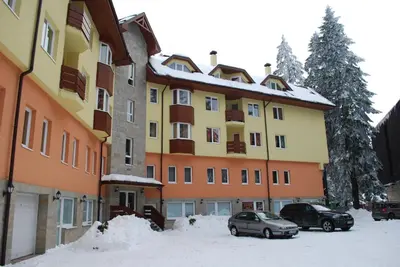 a large building with cars parked in the snow at Studio Royal Plaza sleeps 4 Prime location, distance to ski lift - 50M in Borovets