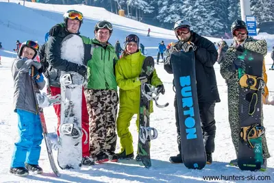 a group of people standing in the snow holding snowboards at Studio Royal Plaza sleeps 4 Prime location, distance to ski lift - 50M in Borovets