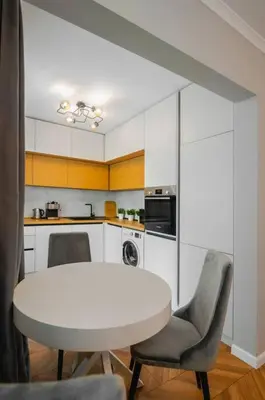 a kitchen with a white table and two chairs at Lozenets Apartment in Sofia