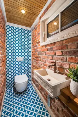 a bathroom with a brick wall and a sink and a toilet at Alexandra's City Center Apartment III in Sofia