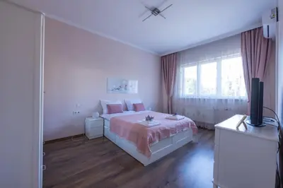 a white bedroom with a bed and a television at Julie Suite Top Center in Sofia