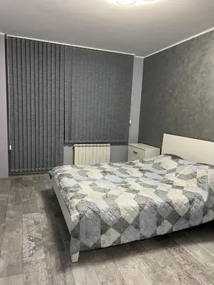 a bedroom with a large bed and a large window at Nice new apartment in Sofia