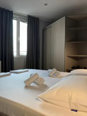 a bedroom with a bed with towels on it at Апартаменти в сърцето на парка in Sandanski