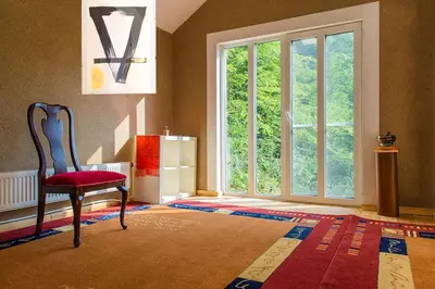 a room with a chair and a large window at Стаи за гости в Ритрийт Център 