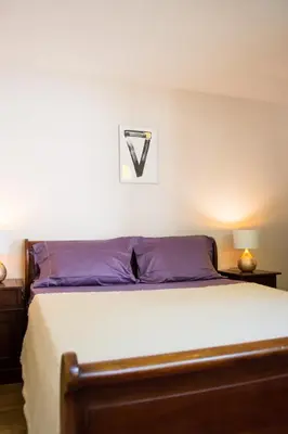 a bedroom with a bed with a white bedspread at Стаи за гости в Ритрийт Център 