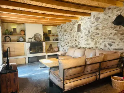 a living room with a couch and a stone wall at Подковите in Karlovo