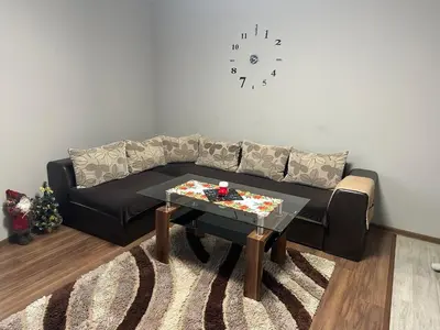 a living room with a black couch and a table at Brown Mur in Sofia