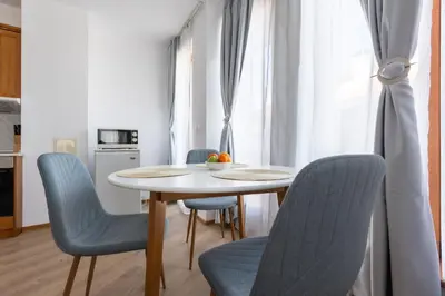 a dining room with a table and blue chairs at Light One Bed Flat next to the Ski Lift in Bansko