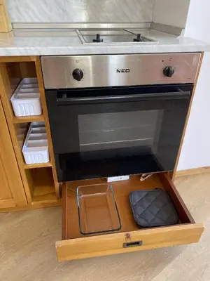 a kitchen stove with a sink in a wooden cabinet at Light One Bed Flat next to the Ski Lift in Bansko