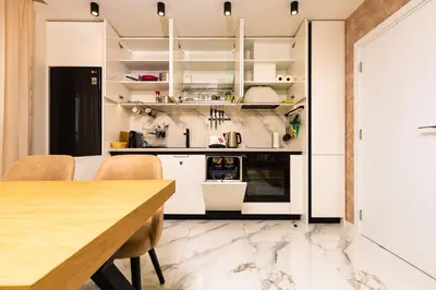 a kitchen with white cabinets and a wooden table at West Haven Apartments - 1BDs in Plovdiv Centre by Flat Mаnager in Plovdiv