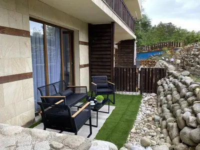 a patio with two chairs and a green lawn at Large One Bedroom with Terrace next to the Ski Lift in Bansko