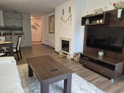 a living room with a large television and a coffee table at Large One Bedroom with Terrace next to the Ski Lift in Bansko