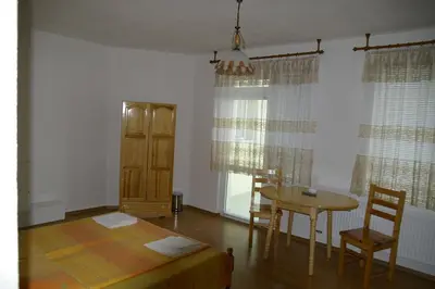 a living room with a table and a table and chairs at Karadzhovy Guest House in Kalofer