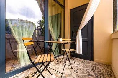 a balcony with a table and chairs next to a door at Chic and Charming 2BD Flat in the Heart of Plovdiv by Flat Mаnager in Plovdiv