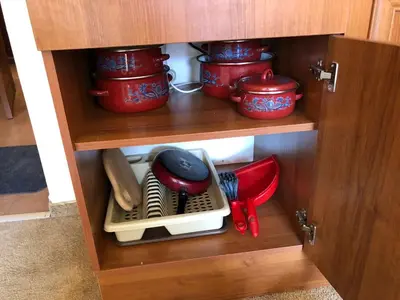 a cupboard with red pots and utensils at Simon1 studio, 2 min to gondola in Bansko