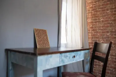 a desk in a room with two chairs and a brick wall at The Cozy Corner in Sofia
