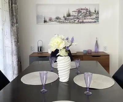 a table with two plates and a vase with flowers at Si apartments Free Parking in Sofia
