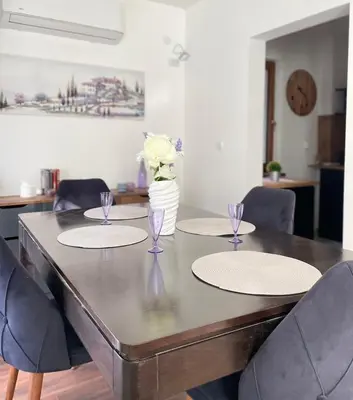 a dining room table with four chairs and a vase of flowers at Si apartments Free Parking in Sofia