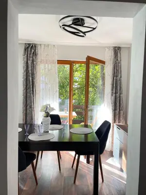 a dining room with a table and chairs and a window at Si apartments Free Parking in Sofia