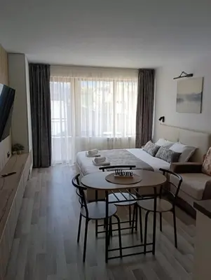 a living room with a table and a couch at Monfort В in Bansko