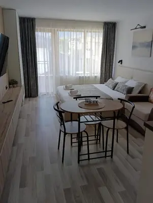 a living room with a table and a couch at Monfort В in Bansko