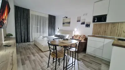a kitchen and a living room with a table and a couch at Monfort В in Bansko