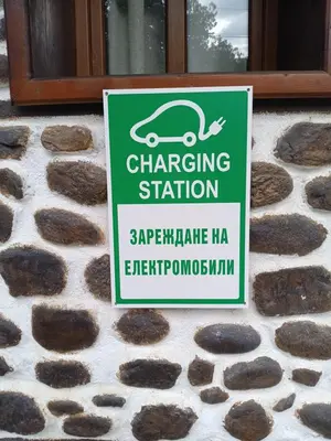 a sign for a car charging station on a building at Хотел Марио in Melnik