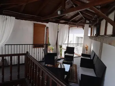 a room with chairs and a staircase with white curtains at Хотел Марио in Melnik