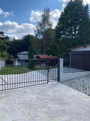 a gate in front of a house with a yard at Villa Yarema Mountain Relax with Hot Jacuzzi & Sauna by BookVillaBG in Zheleznitsa