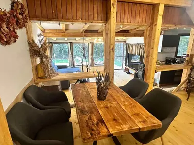 a dining room with a wooden table and chairs at Villa Yarema Mountain Relax with Hot Jacuzzi & Sauna by BookVillaBG in Zheleznitsa