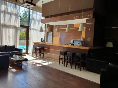 a lobby with a bar with chairs and a table at Apartment ZAX B7 in Terra Complex in Bansko