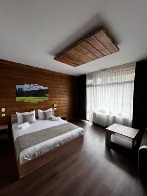a bedroom with a large bed and a couch at Райски кът “Еленова поляна” in Dobărsko