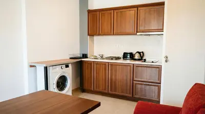 a kitchen with wooden cabinets and a washer and dryer at Mountain Paradise 4 - 1 Bedroom - Gondola, 100m away - Washer in Bansko