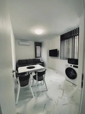 a living room with a table and two chairs at Апартамент Узунови in Sandanski