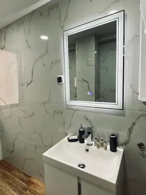 a bathroom with a white sink and a mirror at Апартамент Узунови in Sandanski