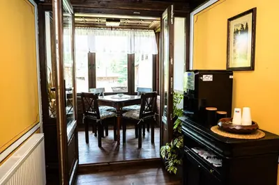 a dining room with a table and chairs and a window at Къща ЕТНО in Koprivshtitsa