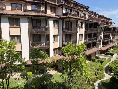 an apartment building with balconies and trees at Next to the Ski Lift Downtown Bansko in Bansko