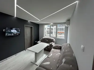 a living room with a table and a chair and a couch at Paradise M Apartments in Plovdiv