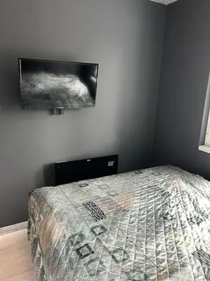 a bedroom with a bed and a tv on the wall at Paradise M Apartments in Plovdiv