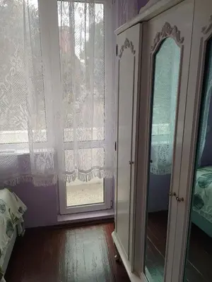 a bedroom with a window and a dresser and a mirror at Apartment Lozenetz in Sofia