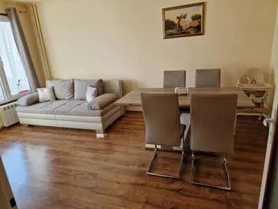 a living room with a couch and a table and chairs at Apartment's Ortakchiev 2 in Sofia