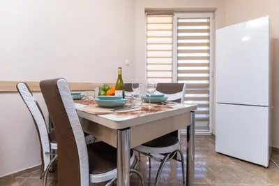 a kitchen with a table with chairs and a white refrigerator at Comfortable 2BR Urban Getaway in City Center by Flat Mаnager in Plovdiv