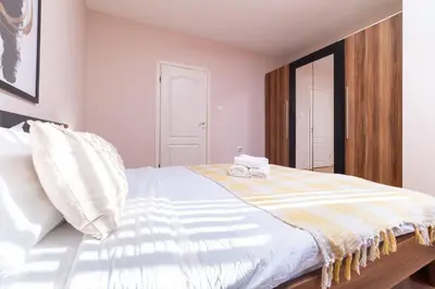 a bedroom with a bed with a striped blanket at Comfortable 2BR Urban Getaway in City Center by Flat Mаnager in Plovdiv