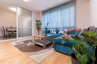 a living room with a blue couch and a table at Comfortable 2BR Urban Getaway in City Center by Flat Mаnager in Plovdiv