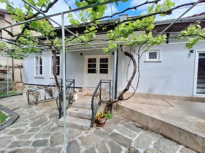 a patio with a tree in front of a house at Musala 1 Bed & Breakfast in Kyustendil