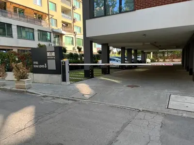 a gate in a parking lot next to a building at Апартамент Комфорт, близо до Летището in Sofia