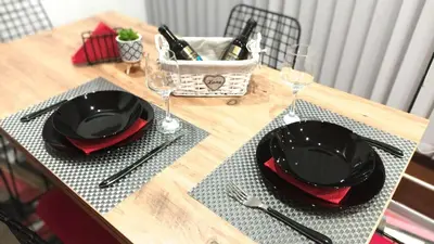 a wooden table with black plates and wine glasses at Boutique Apartment in Plovdiv