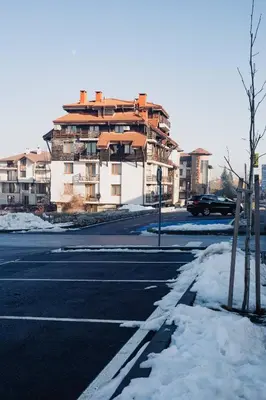 a building on the side of a street with snow at Seasons stay Bansko in Bansko