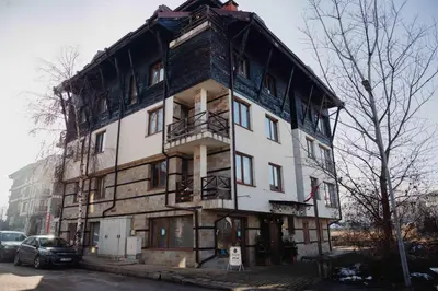 a large white building with a gambrel roof at Seasons stay Bansko in Bansko