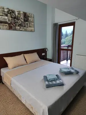 a bedroom with a bed with two towels on it at Shekerdejiiski guest house bansko in Bansko